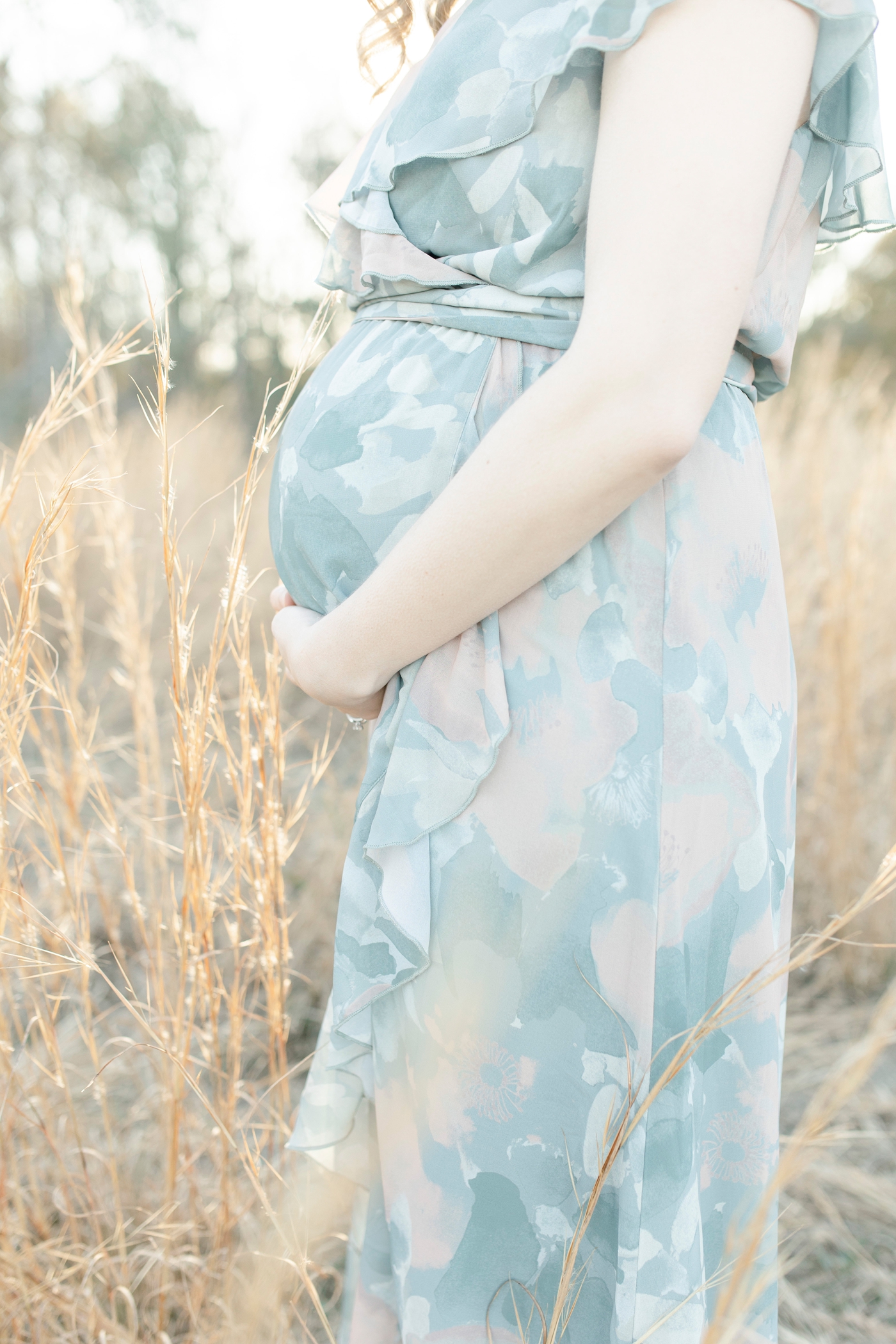 Mom holding her pregnant belly. Photo by Little Sunshine Photography.