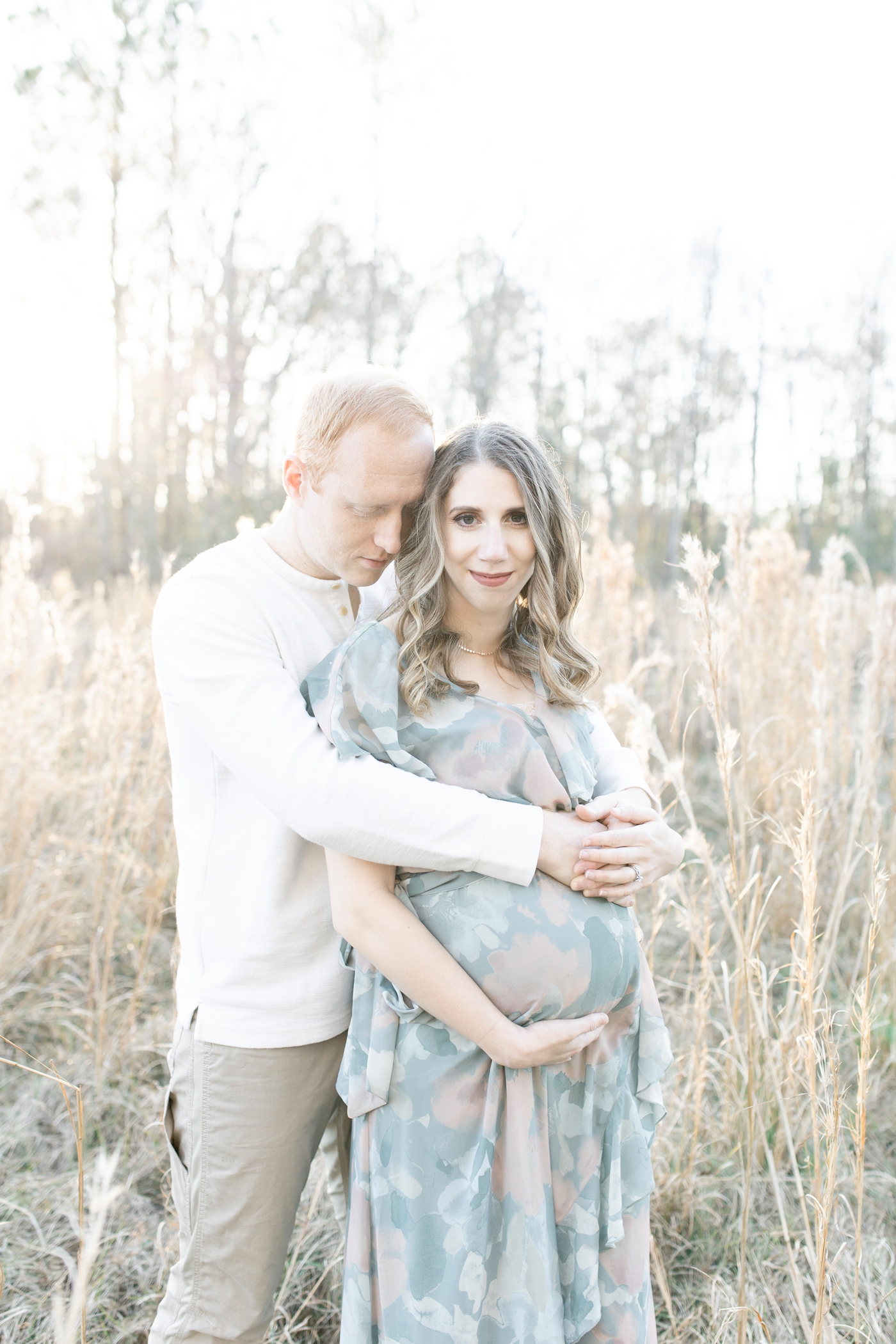 Sunset maternity session in tall golden grass. Photo by Little Sunshine Photography.