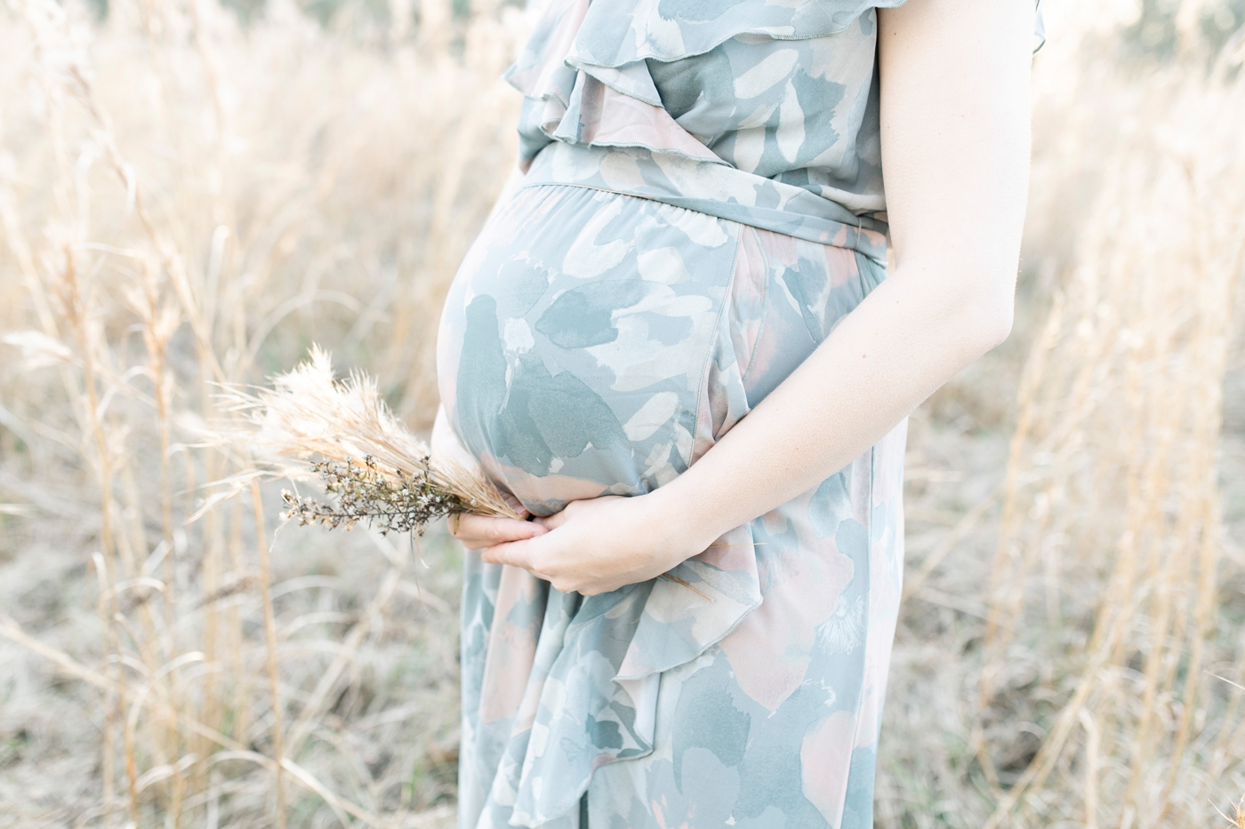 Maternity photoshoot in field. Photo by Little Sunshine Photography.