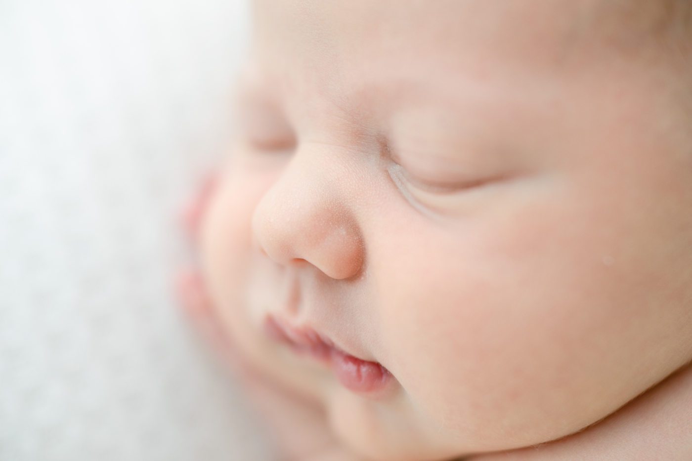 Closeup of baby's face and nose during newborn session with family and sibling. Photos by Little Sunshine Photography.