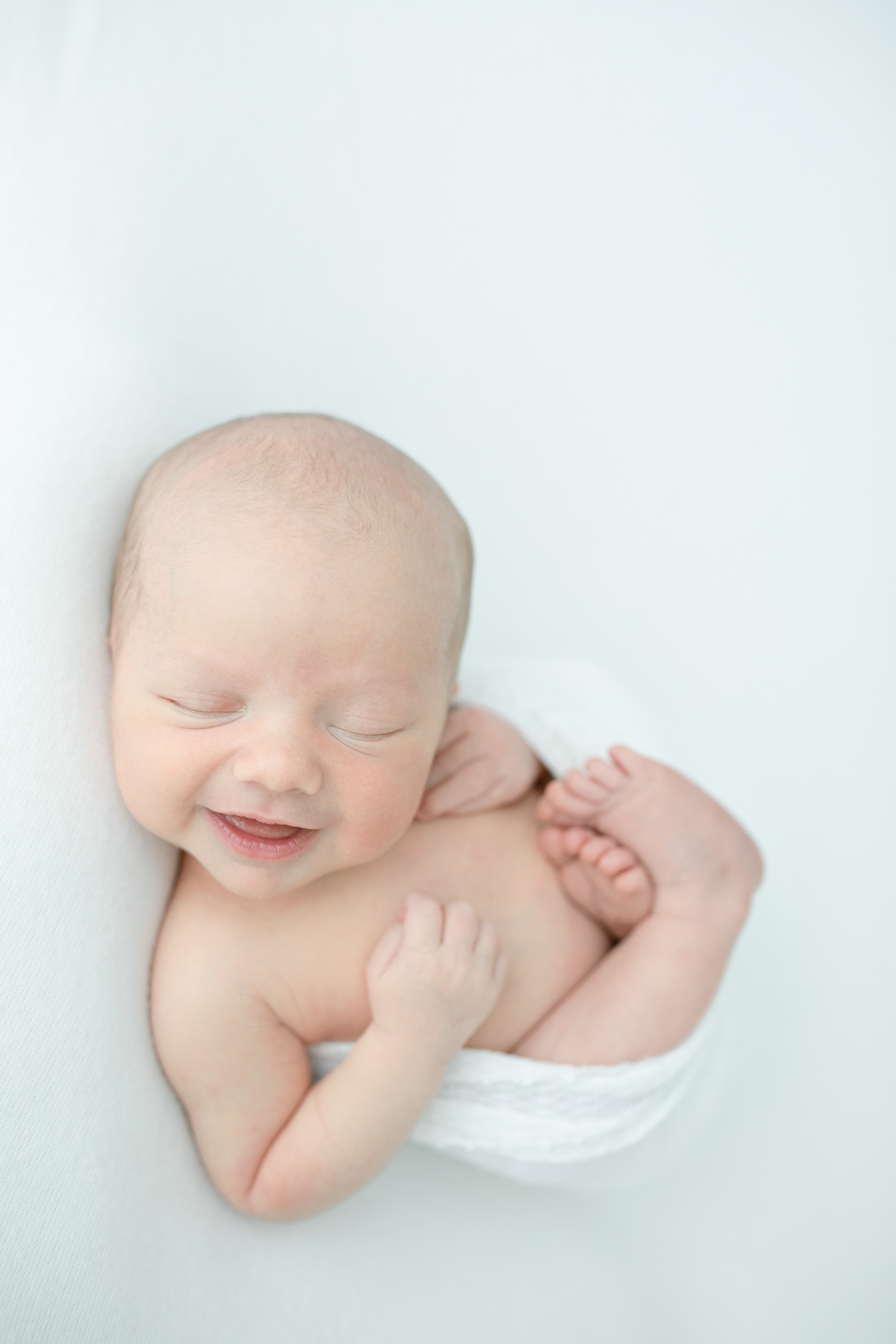 Photo of smiling newborn during session by Gulf Shores MS studio newborn photographer, Little Sunshine Photography.