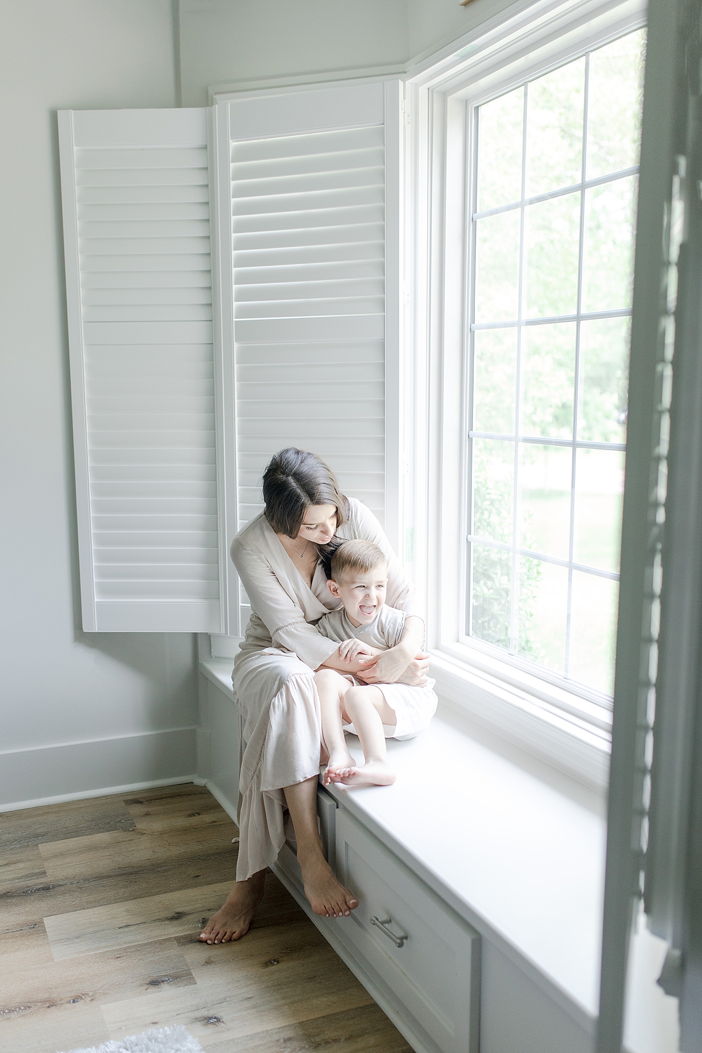 Mom and son sitting in window seat. Photo by Little Sunshine Photography