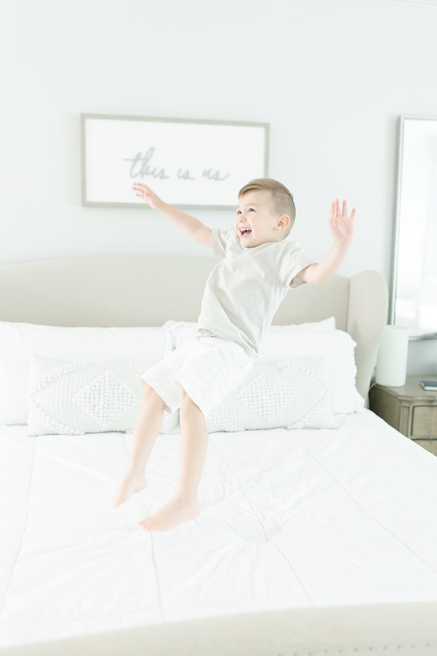 Toddler boy jumping on bed during family photoshoot. Photo by Little Sunshine Photography