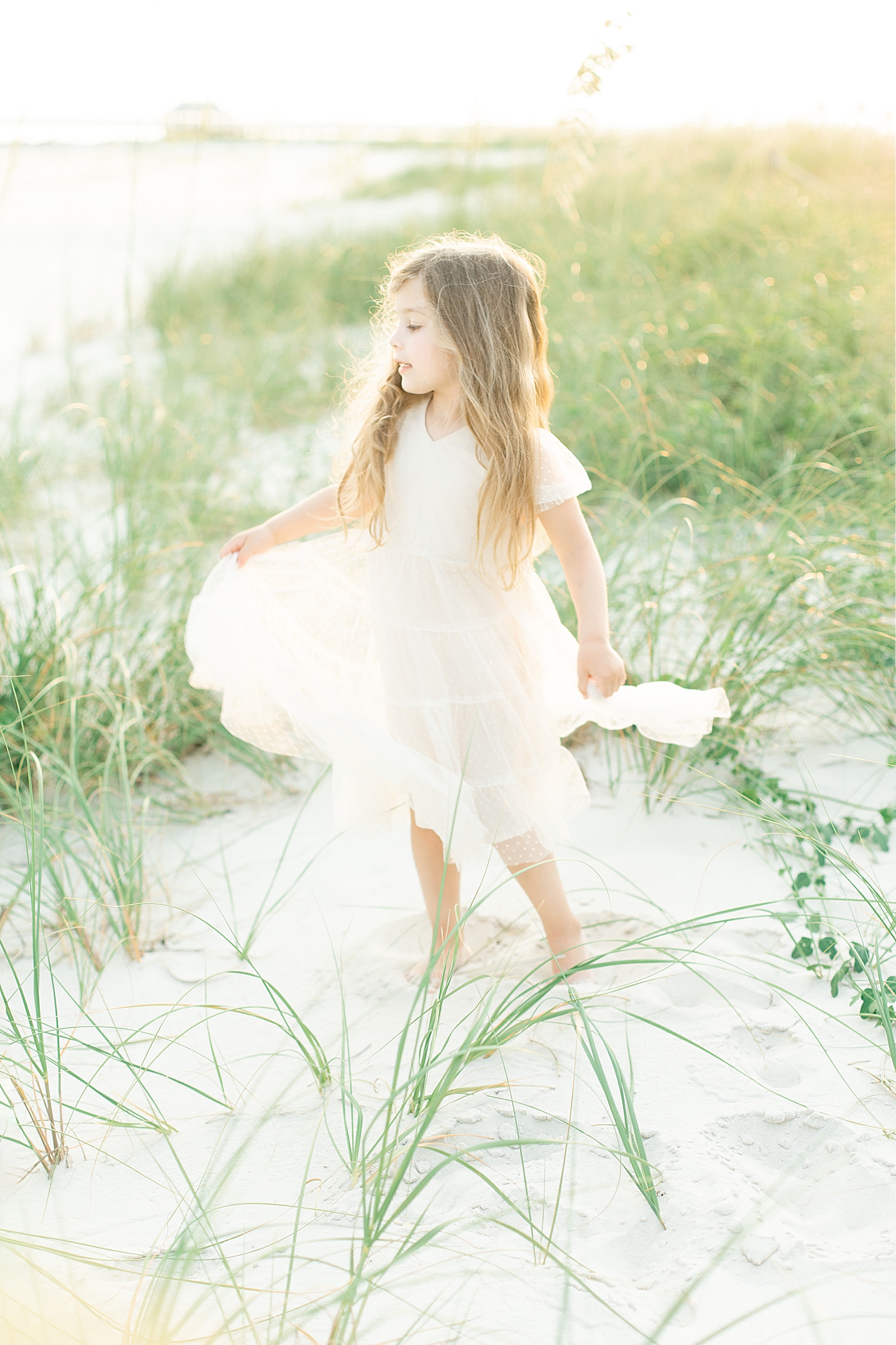 Little girl playing on the beach. Photo by Little Sunshine Photography.