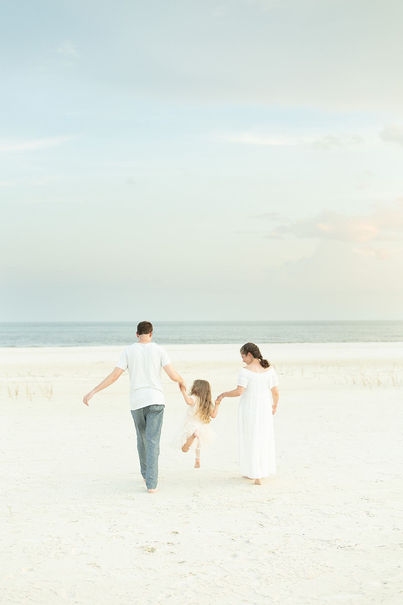 Family walking on the beach. Photo by Little Sunshine Photography.