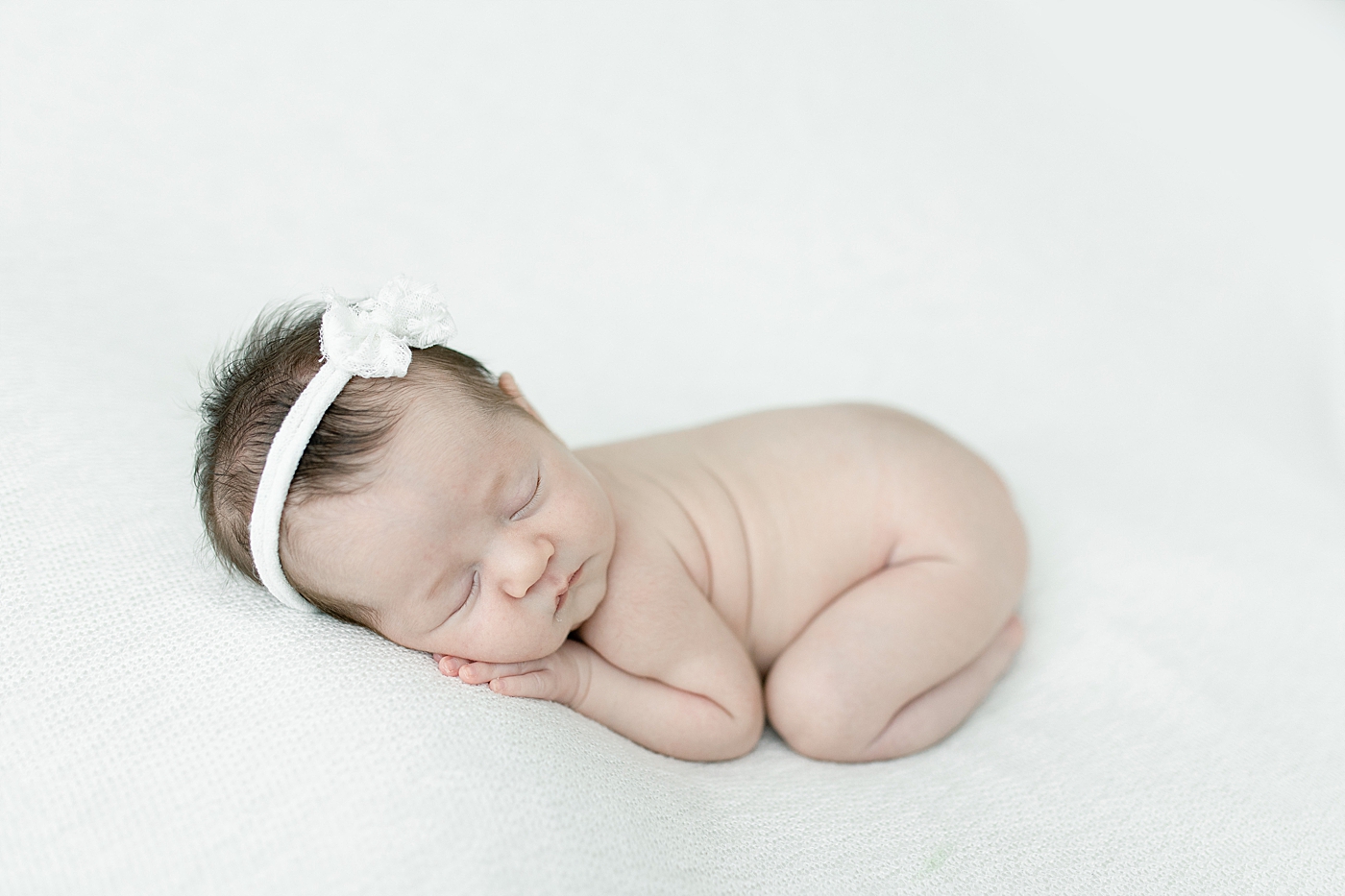 Baby girl posed on belly for newborn photos. Photo by Little Sunshine Photography