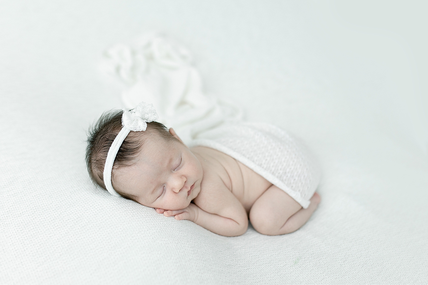 Baby girl posed on belly for newborn photos. Photo by Little Sunshine Photography