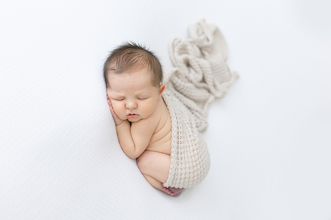 Baby boy laying on stomach for newborn session. Photo by Little Sunshine Photography.