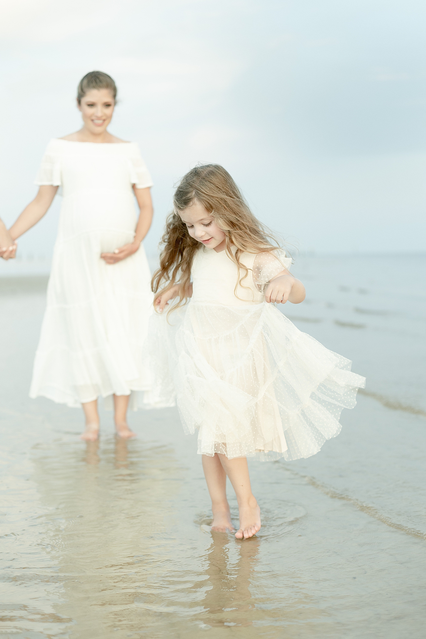 Little girl in white dress walking on the beach | Photo by Little Sunshine Photography