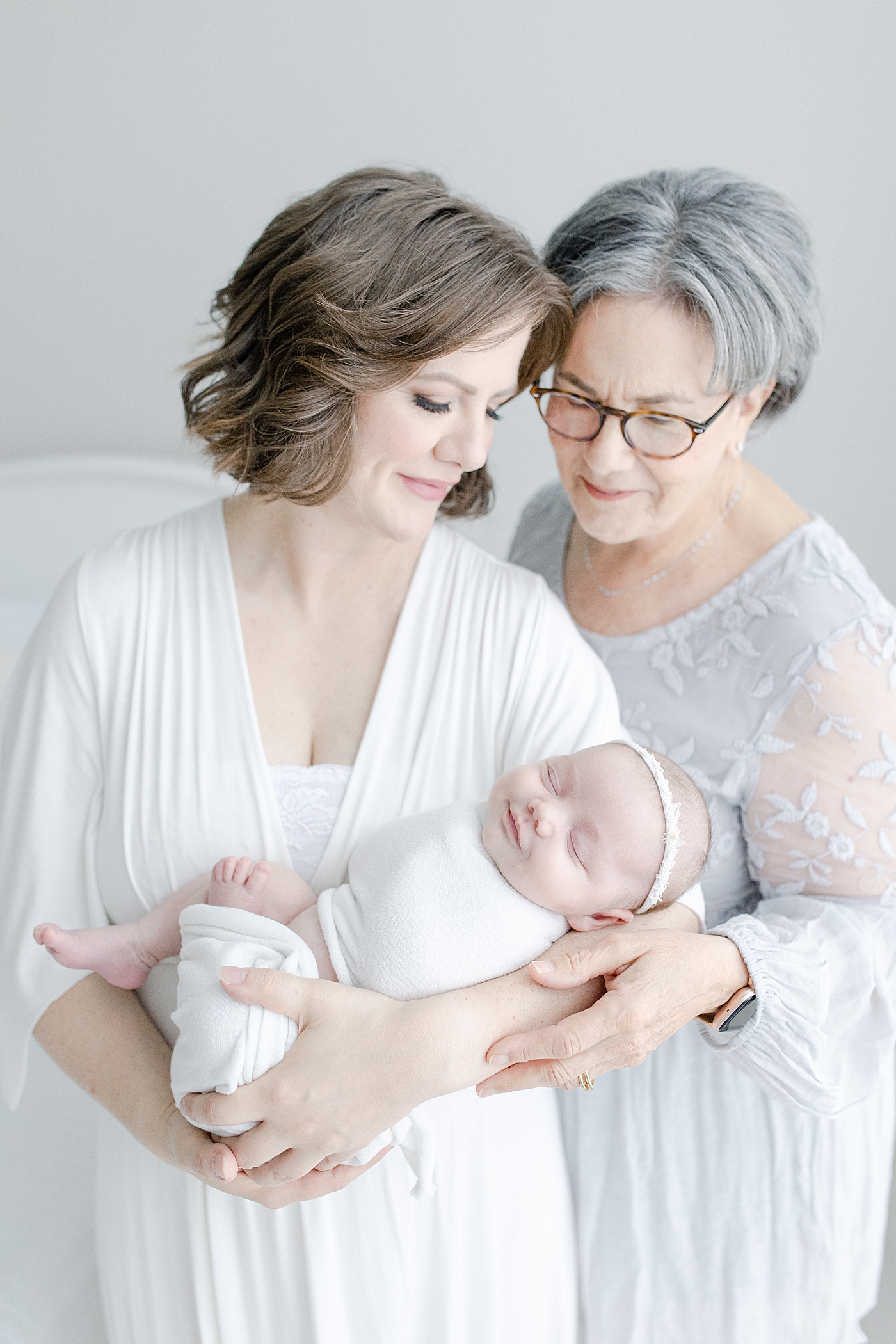 Mom and grandma holding smiling baby girl | Bay St. Louis newborn photographer Little Sunshine Photography