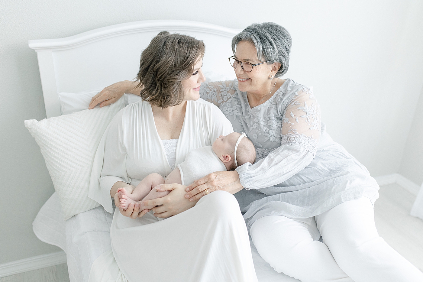 Baby held by mom and grandmother in studio | Bay St. Louis newborn photographer Little Sunshine Photography