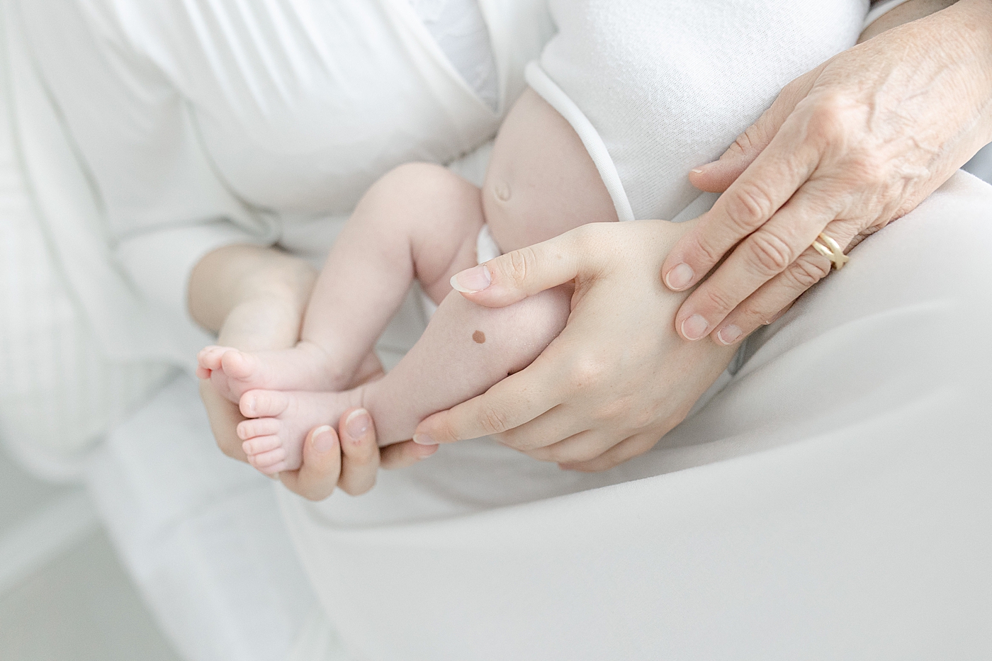 Mom and grandmother cradling baby's feet | Bay St. Louis newborn photographer Little Sunshine Photography