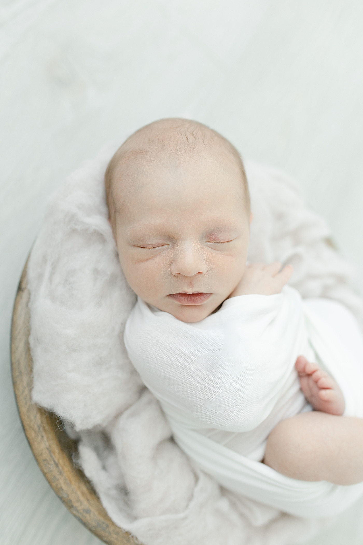 Up close photo of sleeping newborn in white swaddle | Photo by Hattiesburg NB photographer Little Sunshine Photography