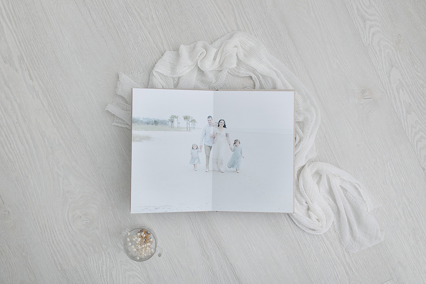 Flatlay of family album on white wood surface | Photo by Little Sunshine Photography