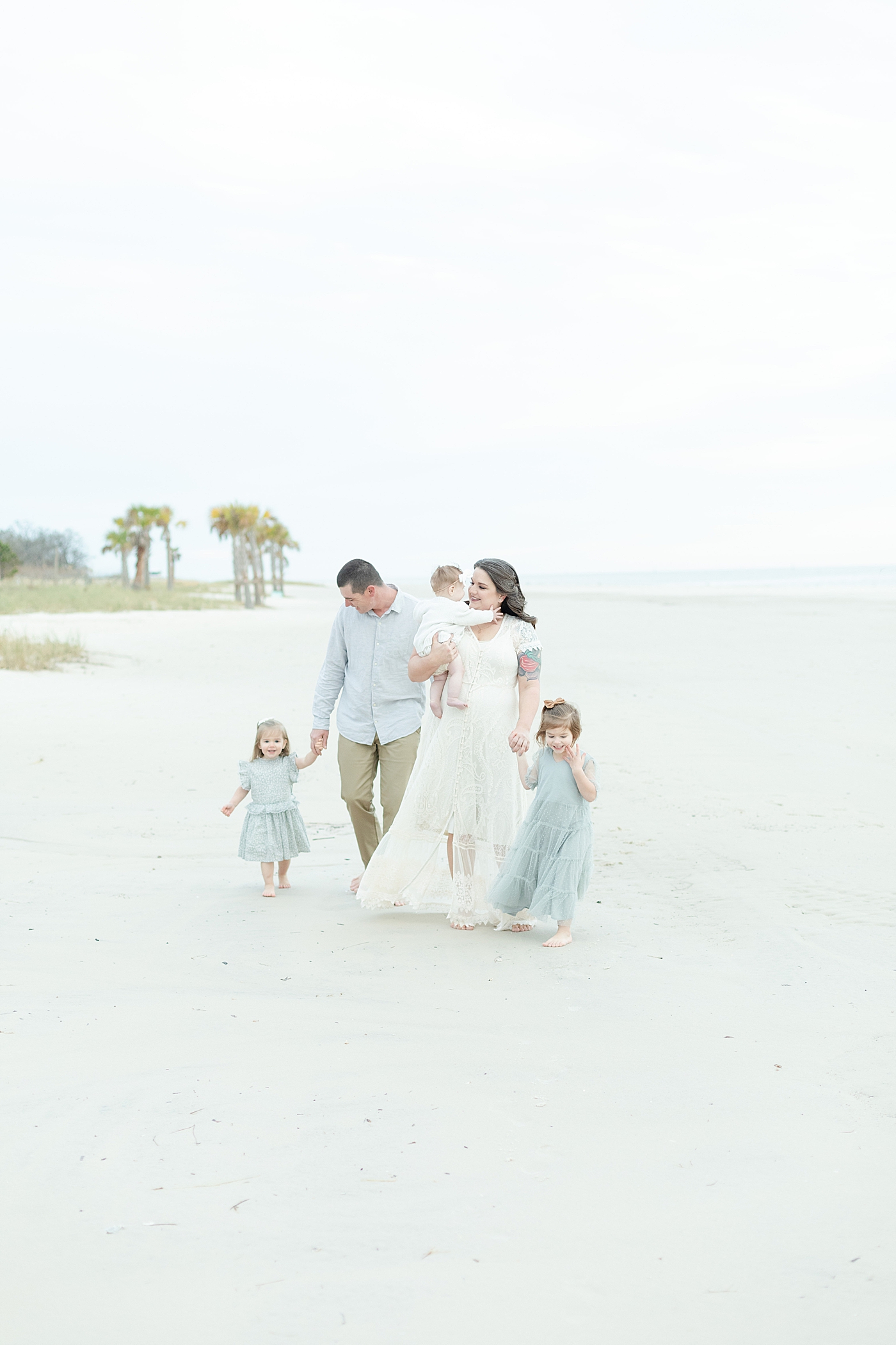 Family walking on the beach | Photo by Little Sunshine Photography