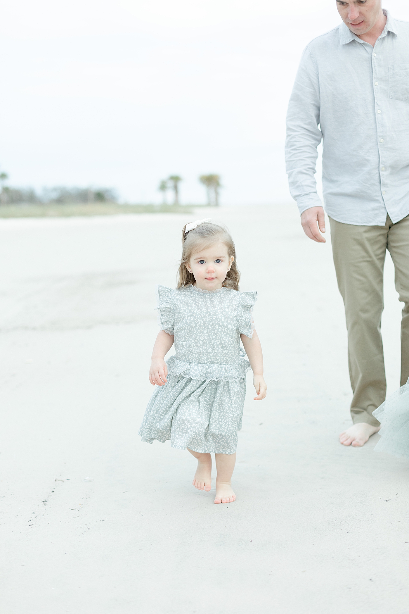 Little girl walking on the beach with family | Photo by Little Sunshine Photography
