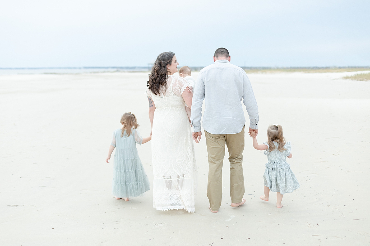 Family in blue and white walking on the beach | Photo by Pascagoula Family Photographer Little Sunshine Photography