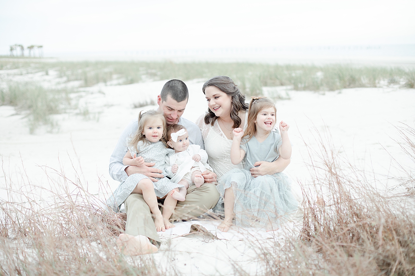 Family of five sitting on Pascagoula beach | Photo by Little Sunshine Photography