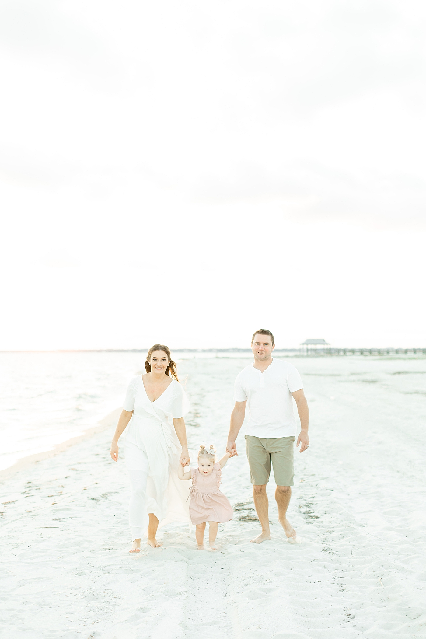 Mom, dad, and toddler baby girl walking on the beach | Photo by Bay St. Louis MS Family Photographer Little Sunshine Photography