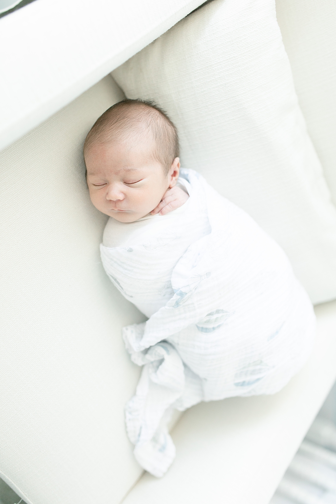 Newborn baby wrapped in muslin swaddle asleep | Photo by Little Sunshine Photography