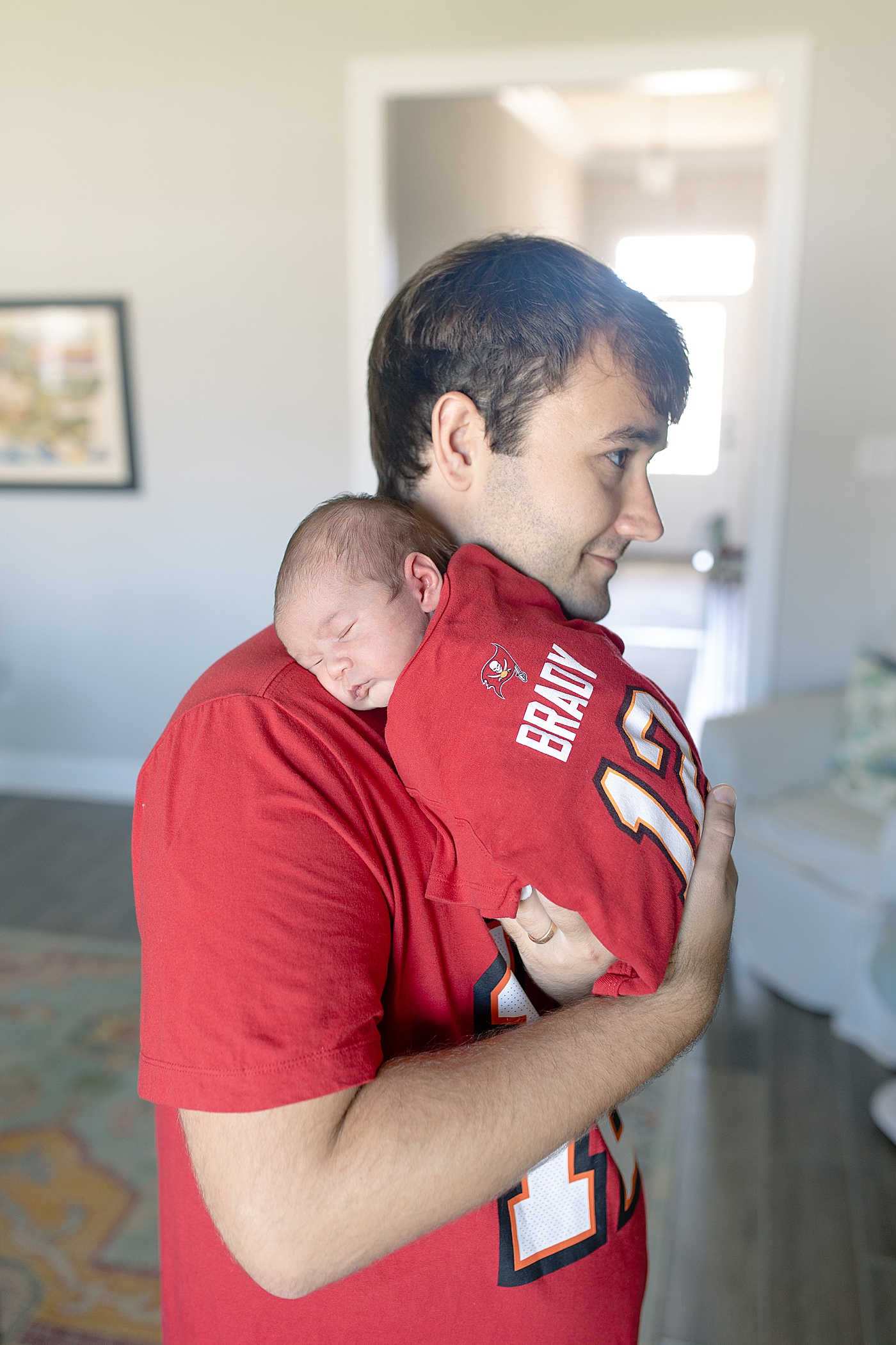 Newborn baby and dad in matching Tom Brady Jerseys | Photo by Little Sunshine Photography