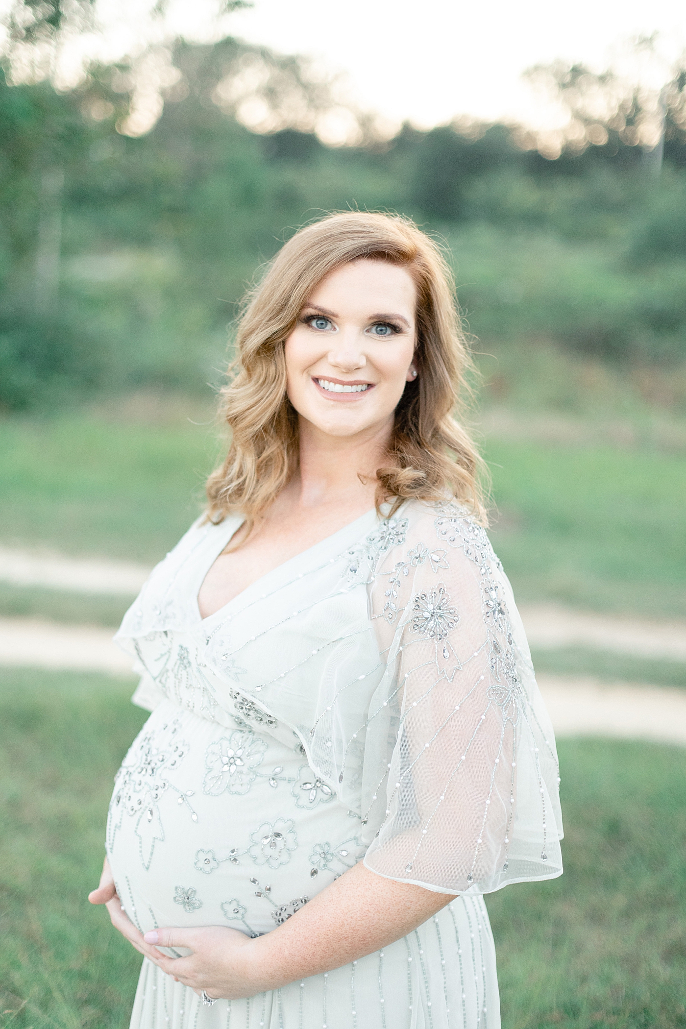 Mother to be in jeweled dress smiling | Photo by Little Sunshine Photography 