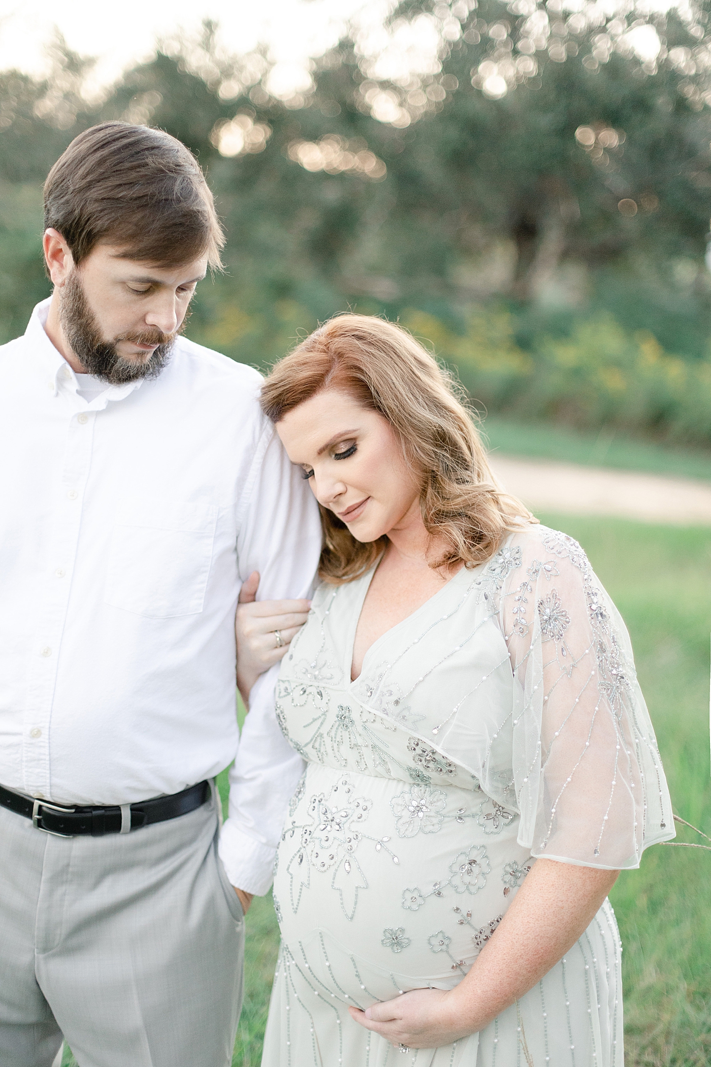 Mom to be leaning her head on husbands shoulder | Photo by Ocean Springs MS Maternity Photographer Little Sunshine Photography 