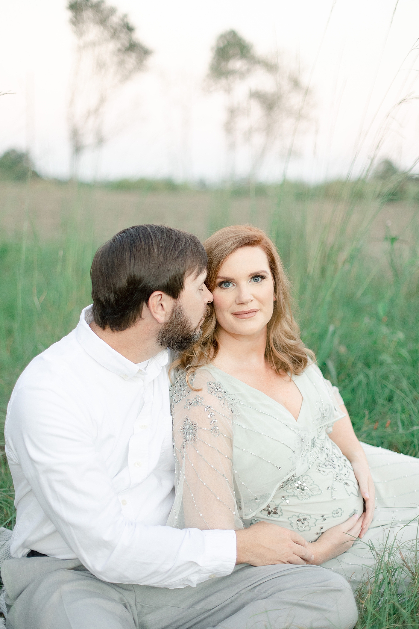 Mother and father to be sitting in the grass | Photo by Little Sunshine Photography 