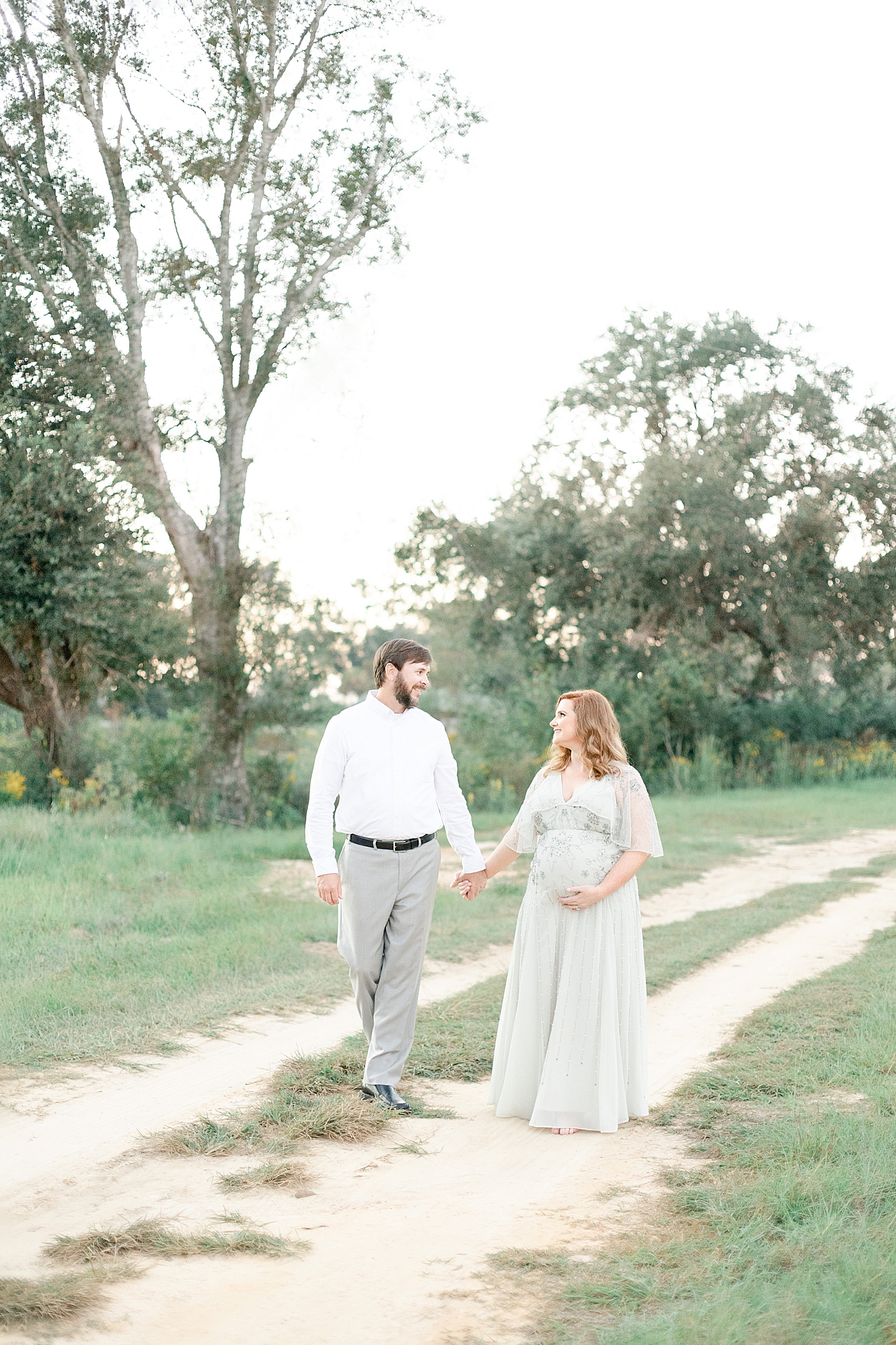 Mother and father walking a dirt path | Photo by Ocean Springs MS Maternity Photographer Little Sunshine Photography 