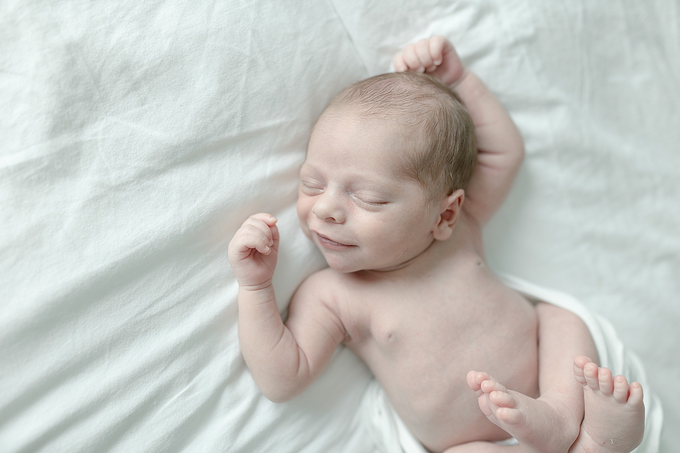 Sleeping newborn baby smirking | Photo by Little Sunshine Photography