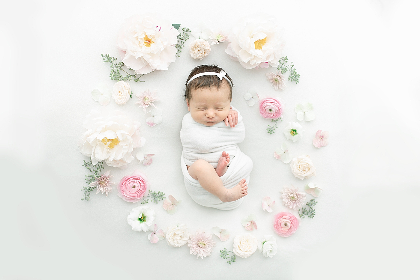 Newborn baby girl surrounded by flowers | Photo by Little Sunshine Photography