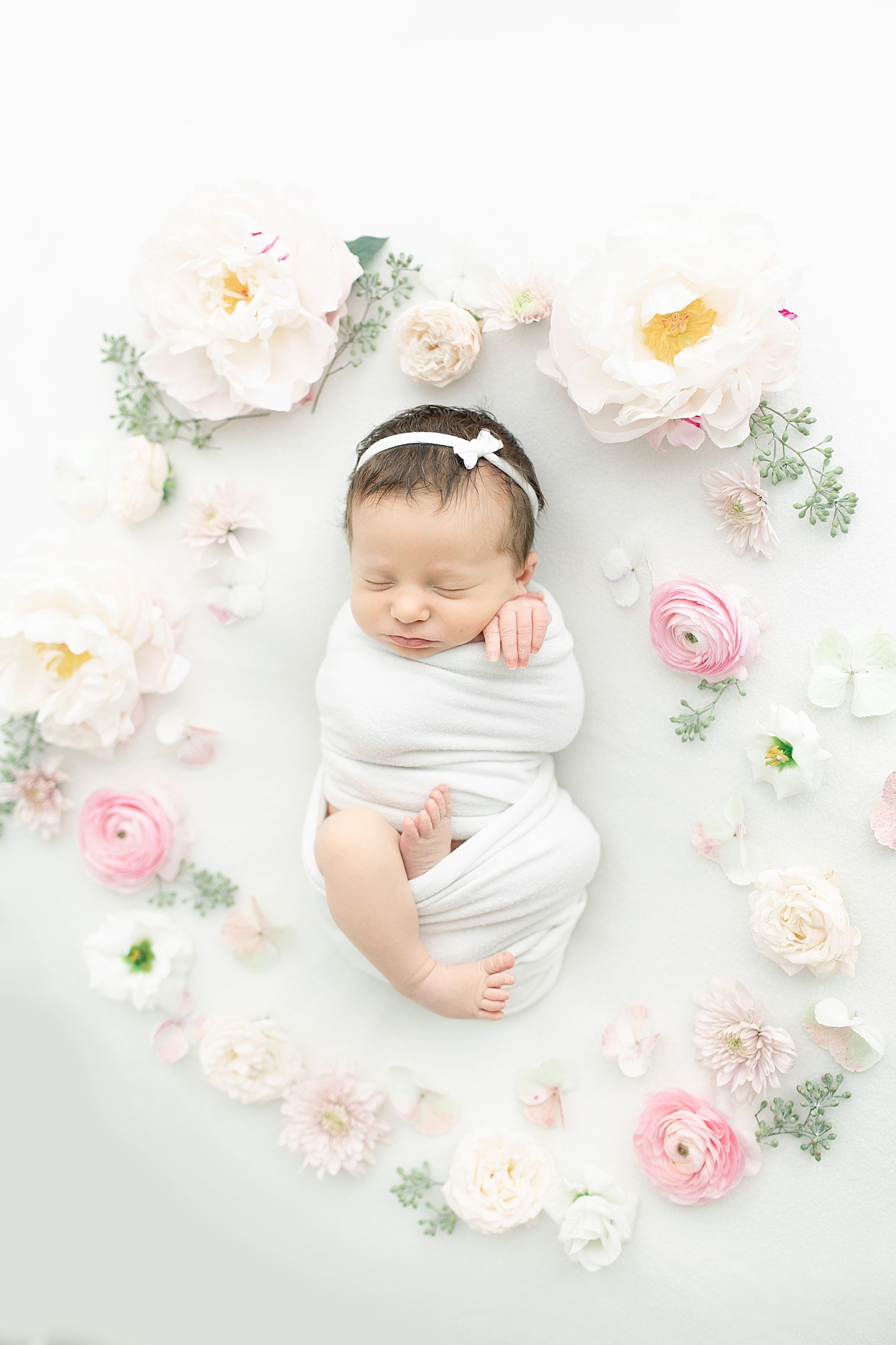 Newborn baby girl surrounded by flowers | Photo by Little Sunshine Photography 