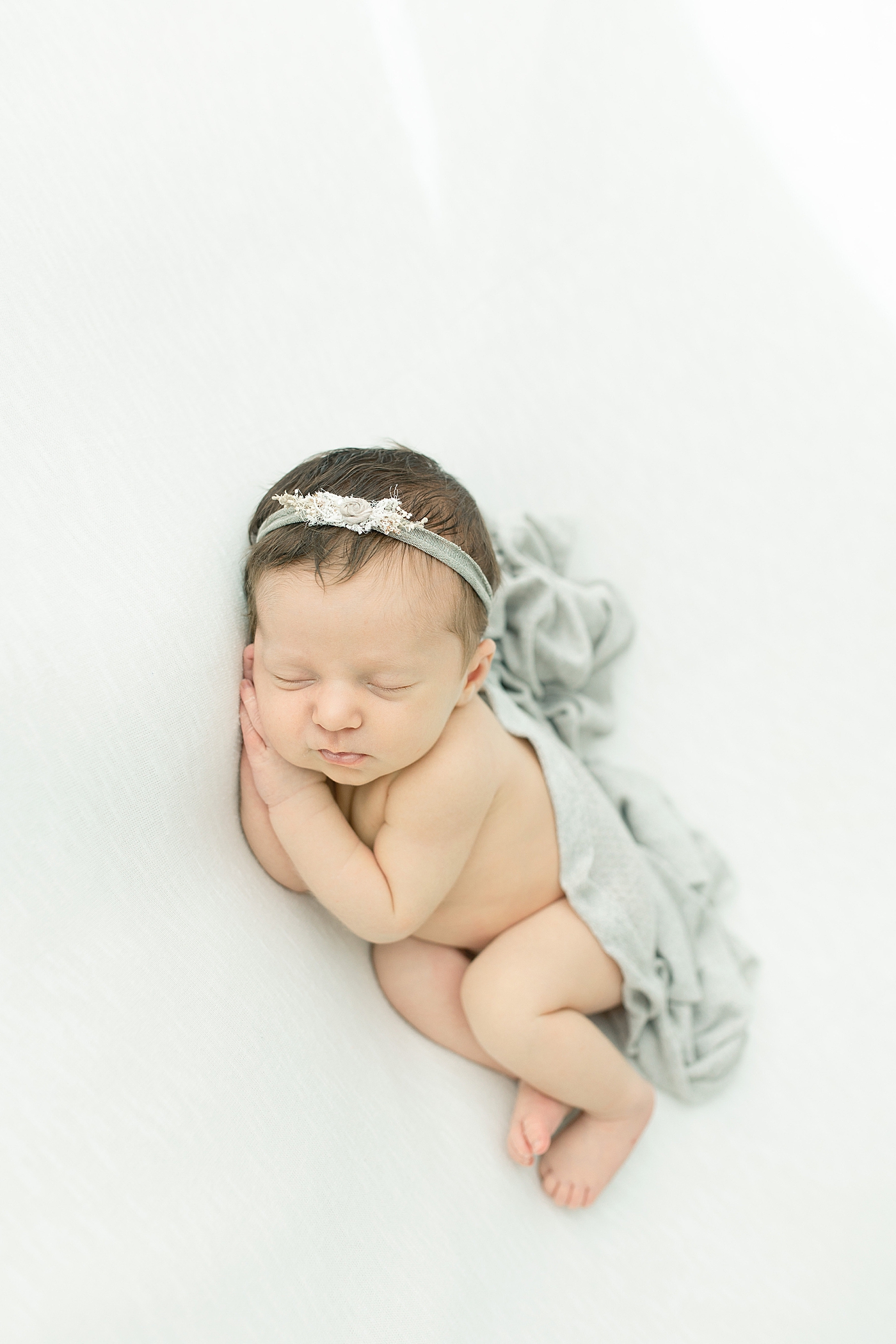 Newborn baby girl in gray swaddle | Photo by Little Sunshine Photography 