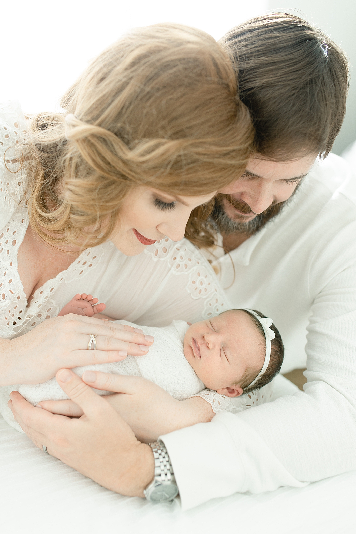 Mom and dad holding sleeping newborn baby girl | Photo by Little Sunshine Photography 
