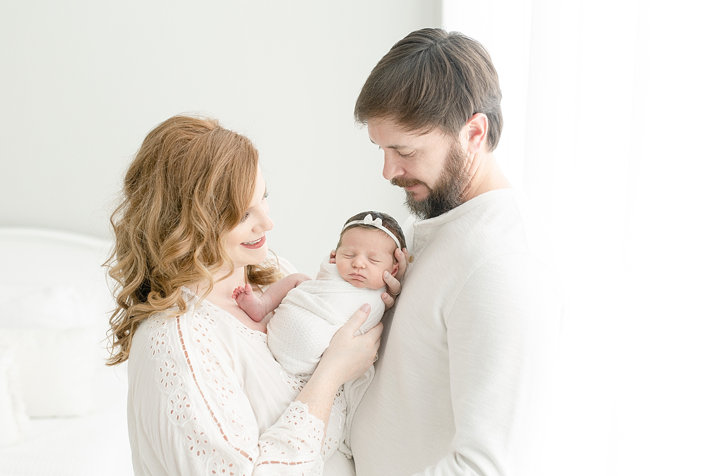 Mom and dad with baby girl in white | Photo by Little Sunshine Photography 