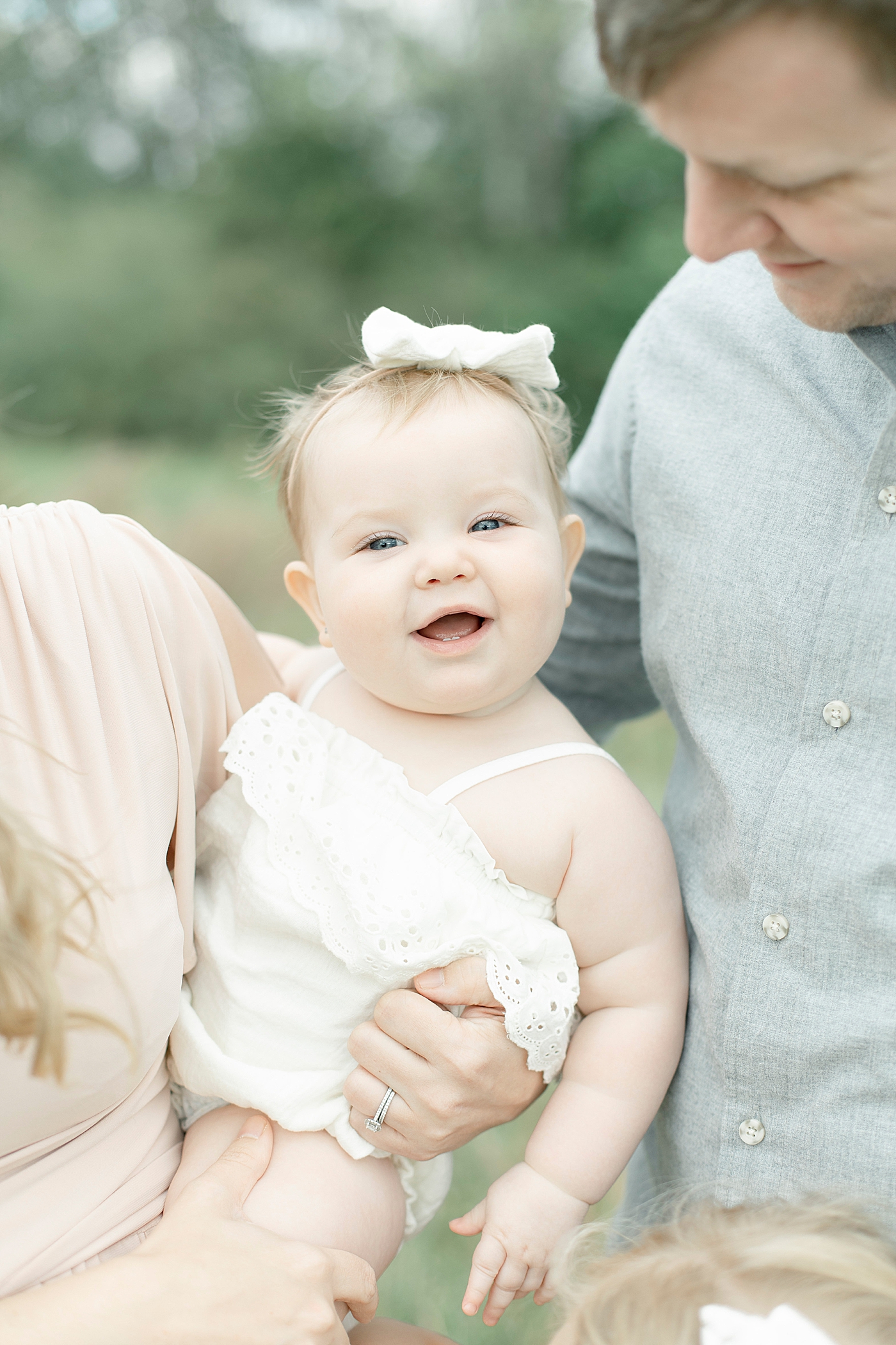 Baby girl smiling with parents | Photo by Little Sunshine Photography 