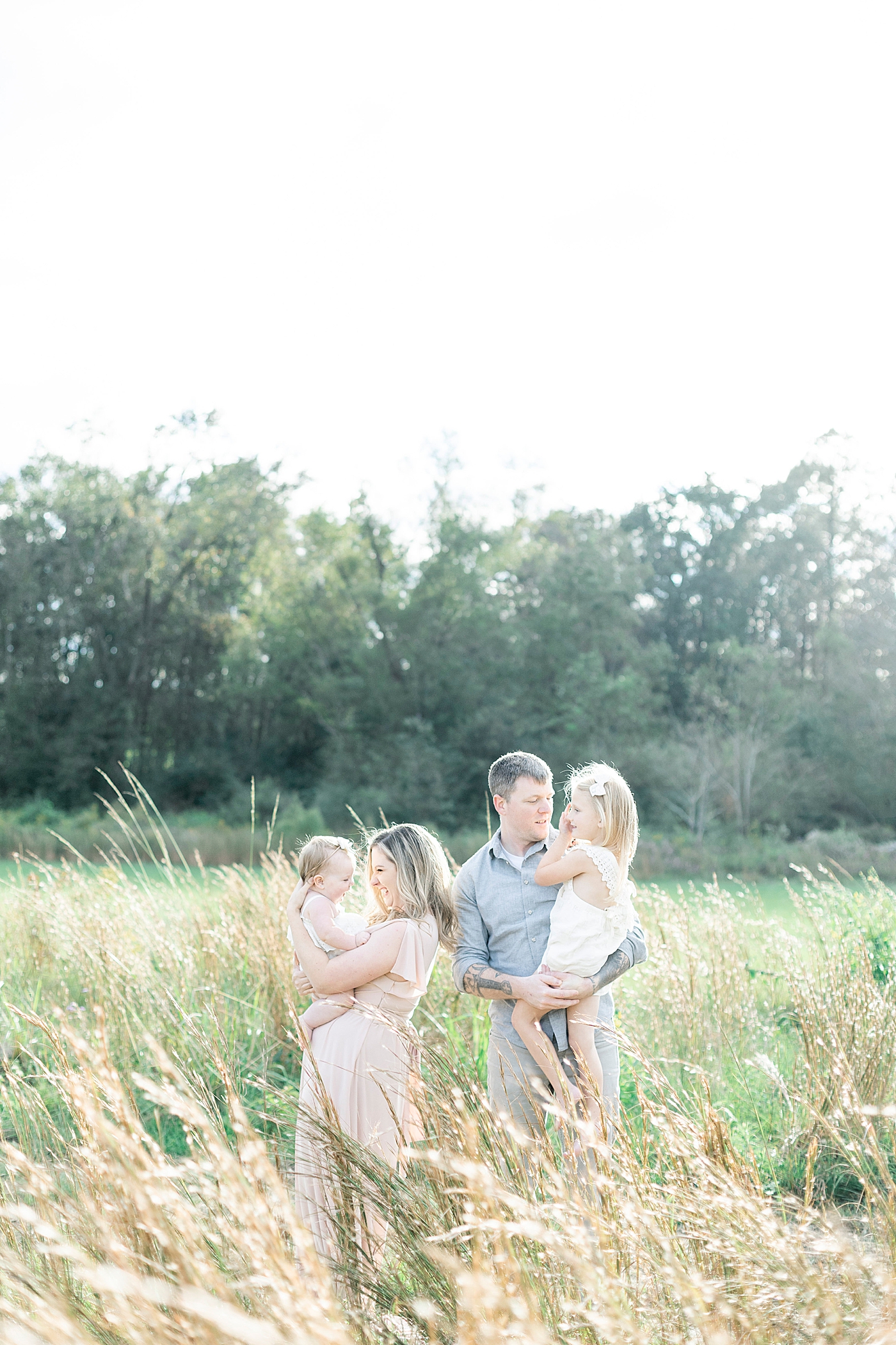 Family snuggling in a field | Photo by Hattiesburg MS family photographer Little Sunshine Photography 
