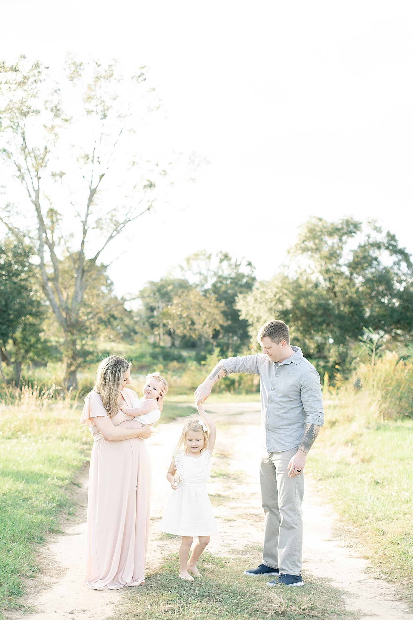 Family interacting while walking down a dirt path | Photo by Little Sunshine Photography 
