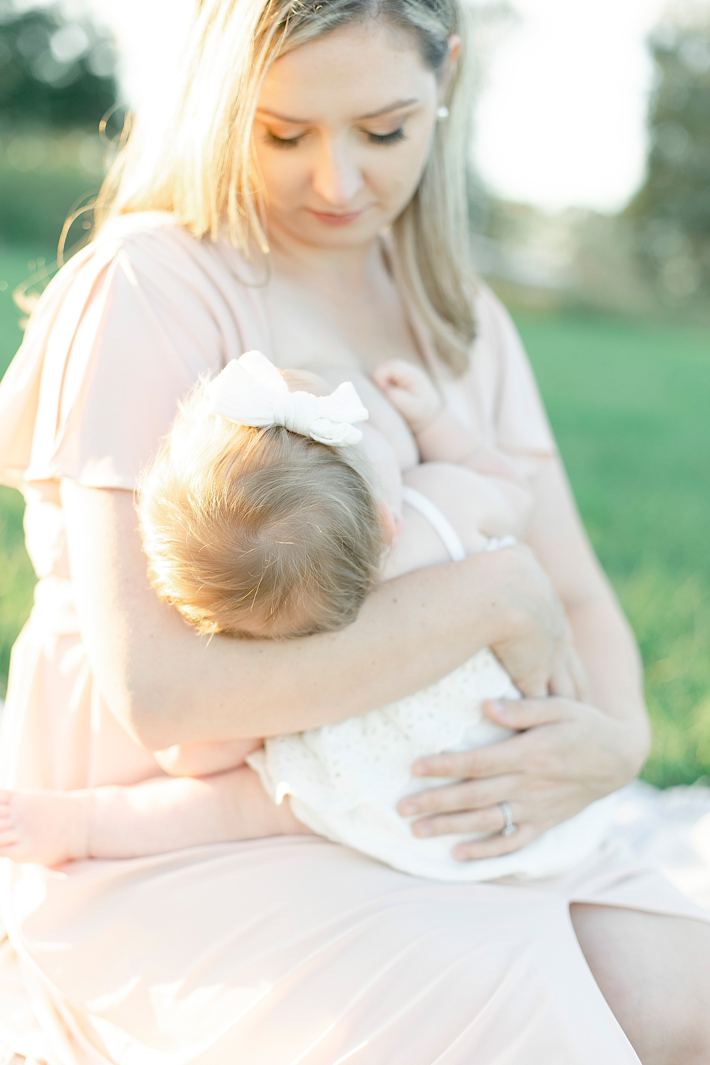 Baby nursing while sitting in the grass with mom | Photo by Little Sunshine Photography 