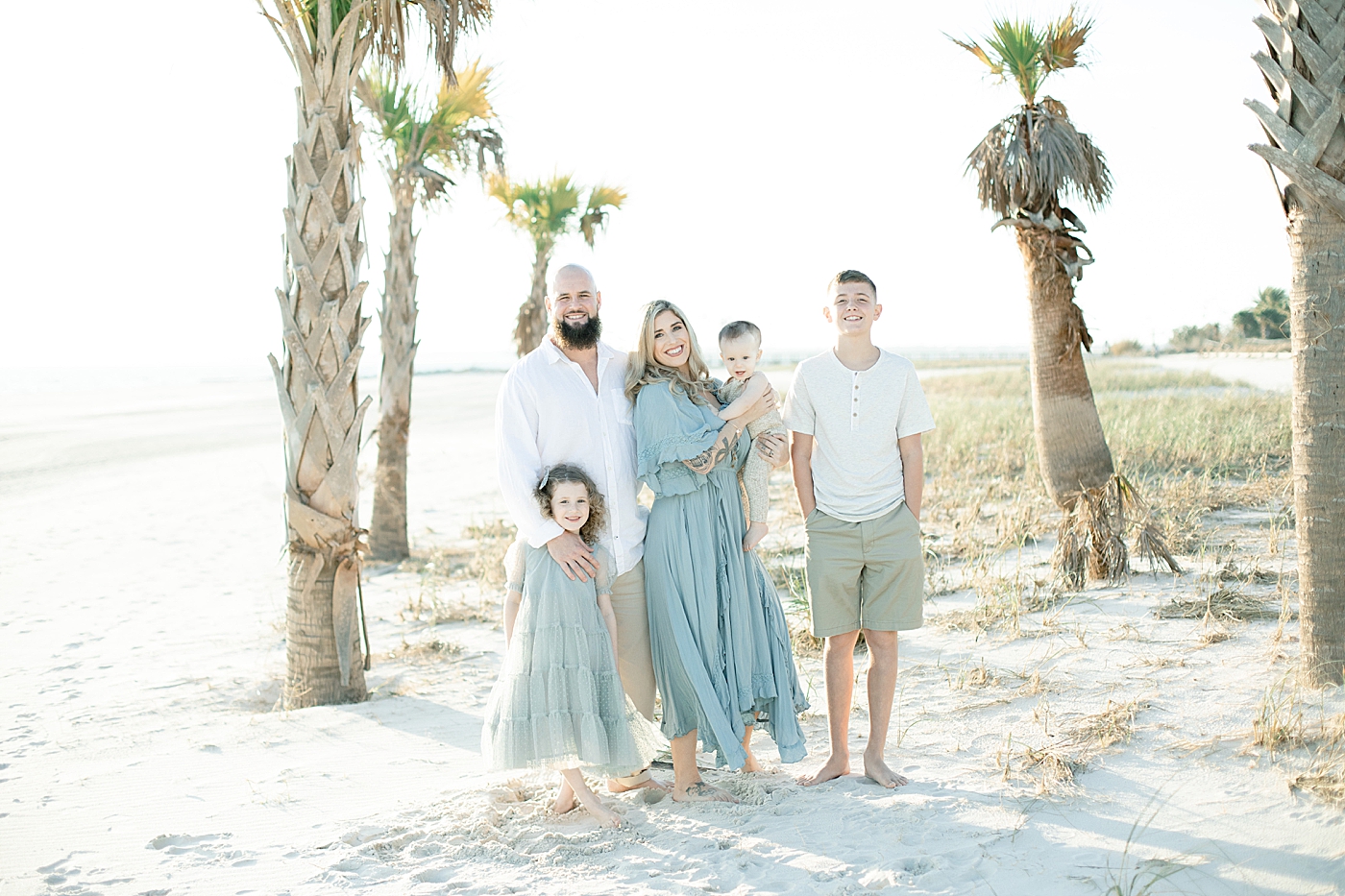 Family of four on the beach in blue | Photo by Little Sunshine Photography