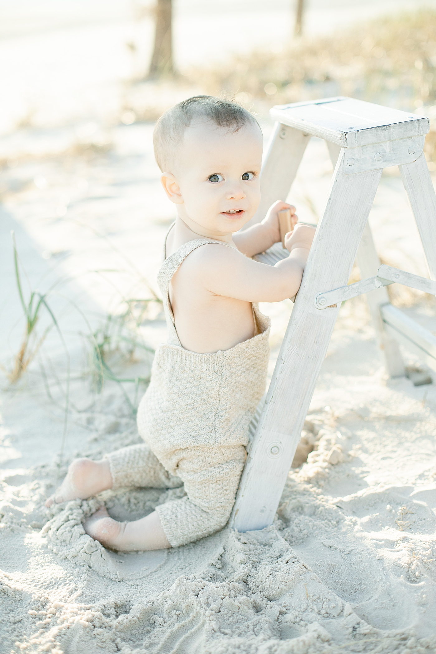 Baby boy practicing standing on the beach | Photo by Ocean Springs Family Photographer Little Sunshine Photography