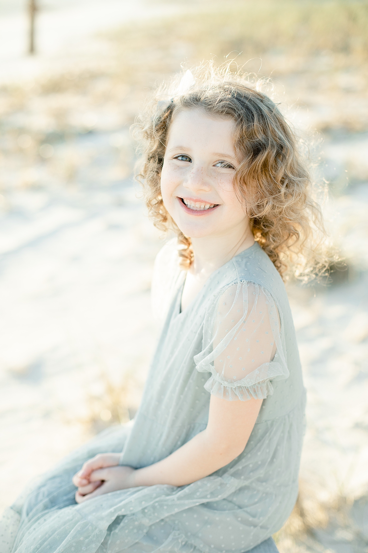  Little girl with red haired curls smiling | Photo by Ocean Springs Family Photographer Little Sunshine Photography