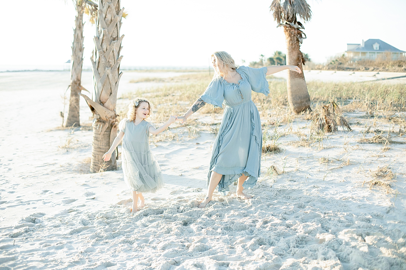 Mom and daughter dancing on the beach | Photo by Little Sunshine Photography