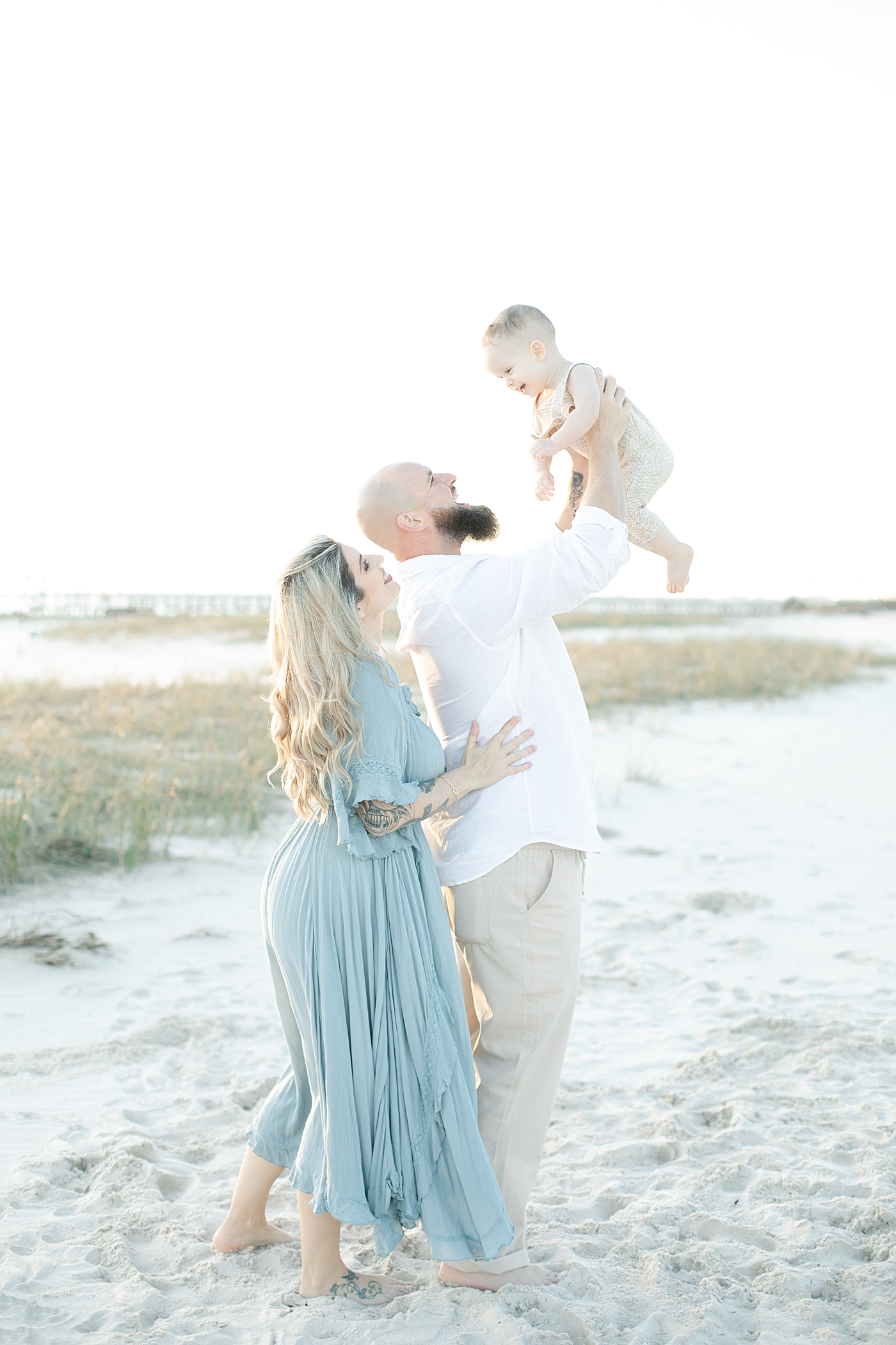 Mom and dad playing with baby on the beach | Photo by Ocean Springs Family Photographer Little Sunshine Photography