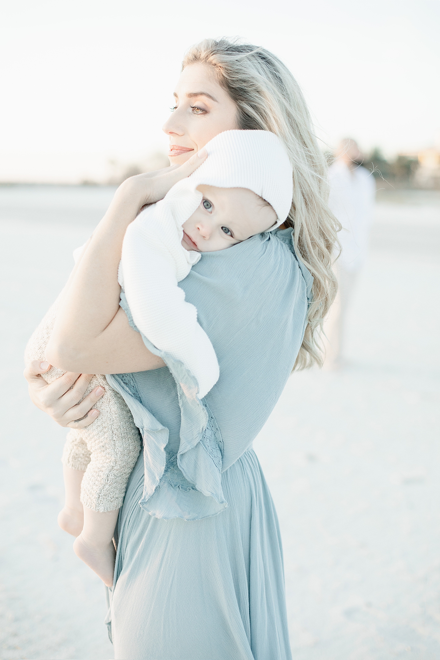 Mom holding baby boy in white hoodie | Photo by Little Sunshine Photography