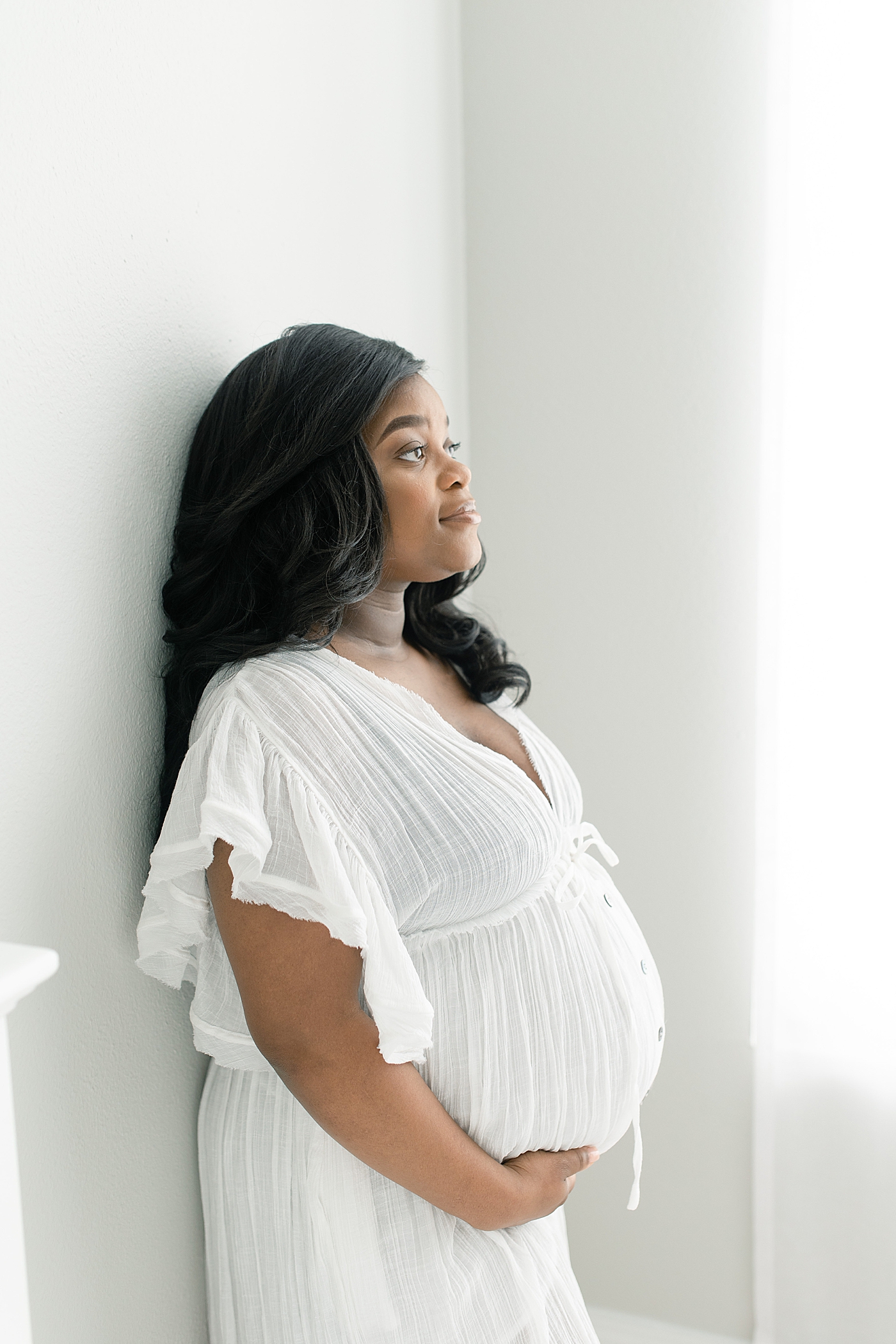 Mother to be in a flowing white dress | Photo by Little Sunshine Photography