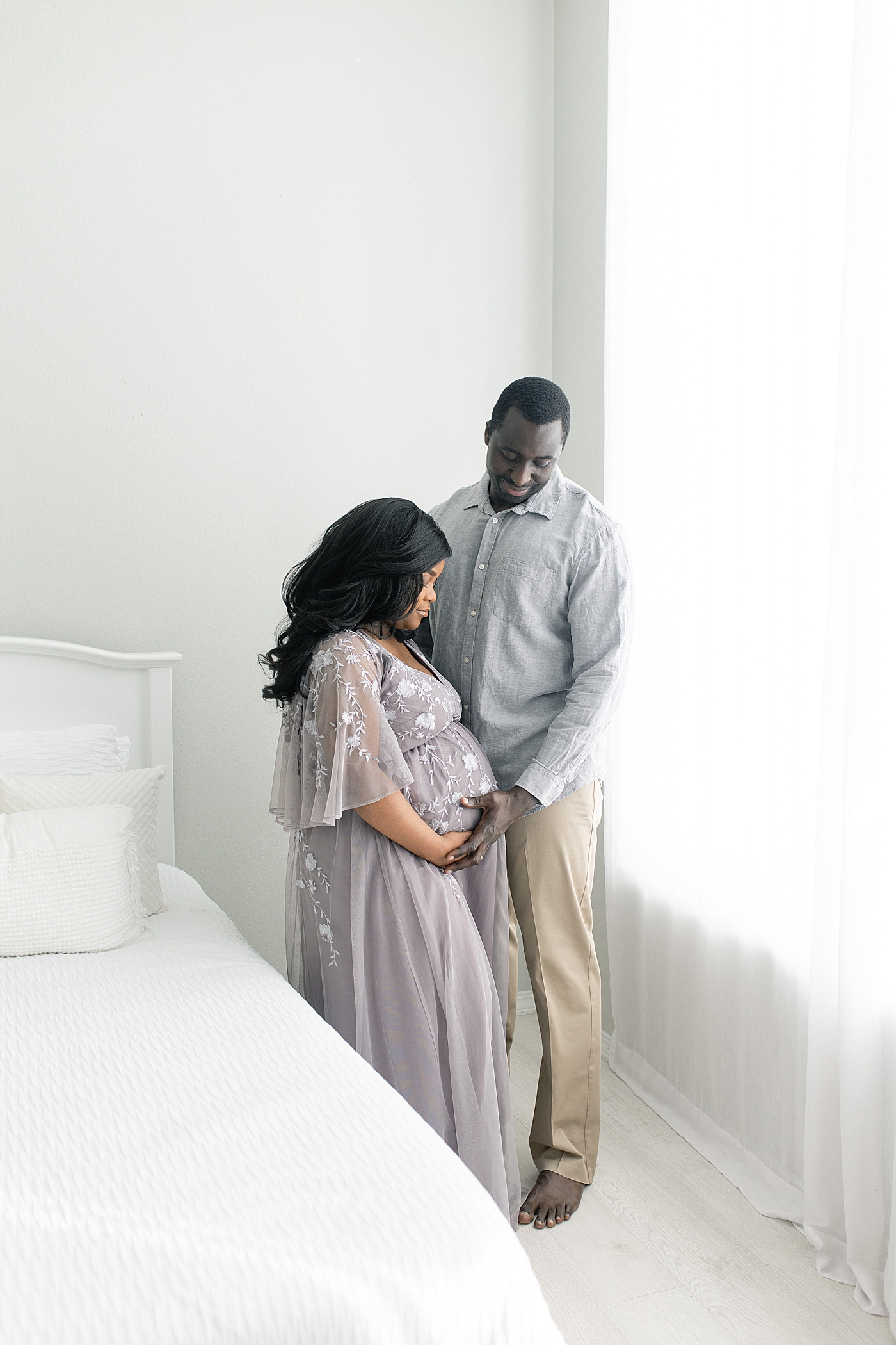 Mother and father to be snuggling in the studio | Photo by Little Sunshine Photography