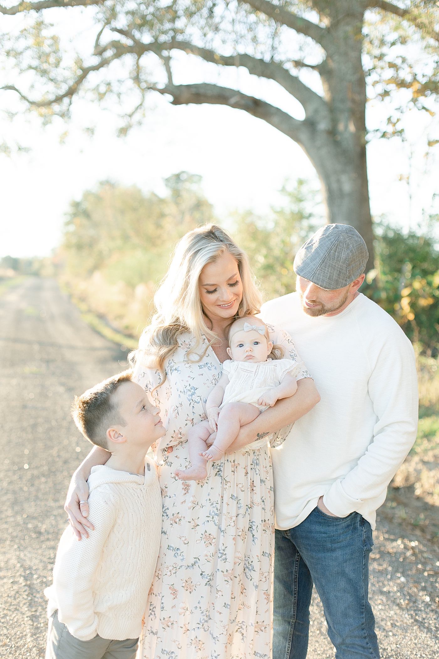 Family snuggling while walking on a dirt path | Photo by Gulfport baby photographer Little Sunshine Photography