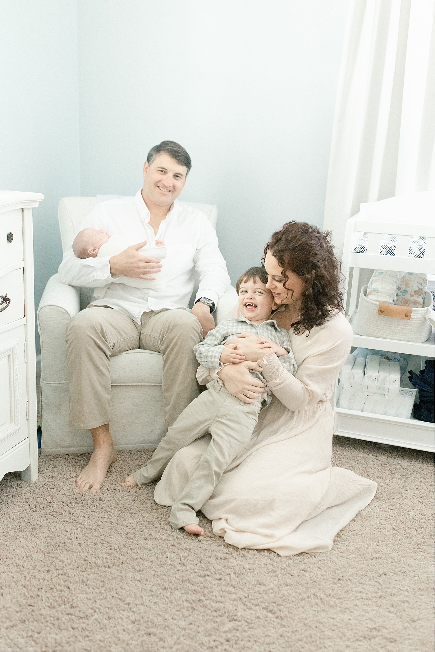 Family snuggling together in baby's nursery | Photo by Pascagoula NB photographer Little Sunshine Photography