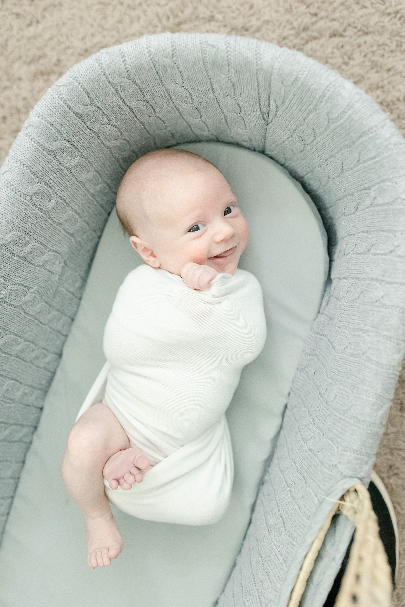 Newborn baby smirking in a mosses blanket | Photo by Pascagoula NB photographer Little Sunshine Photography